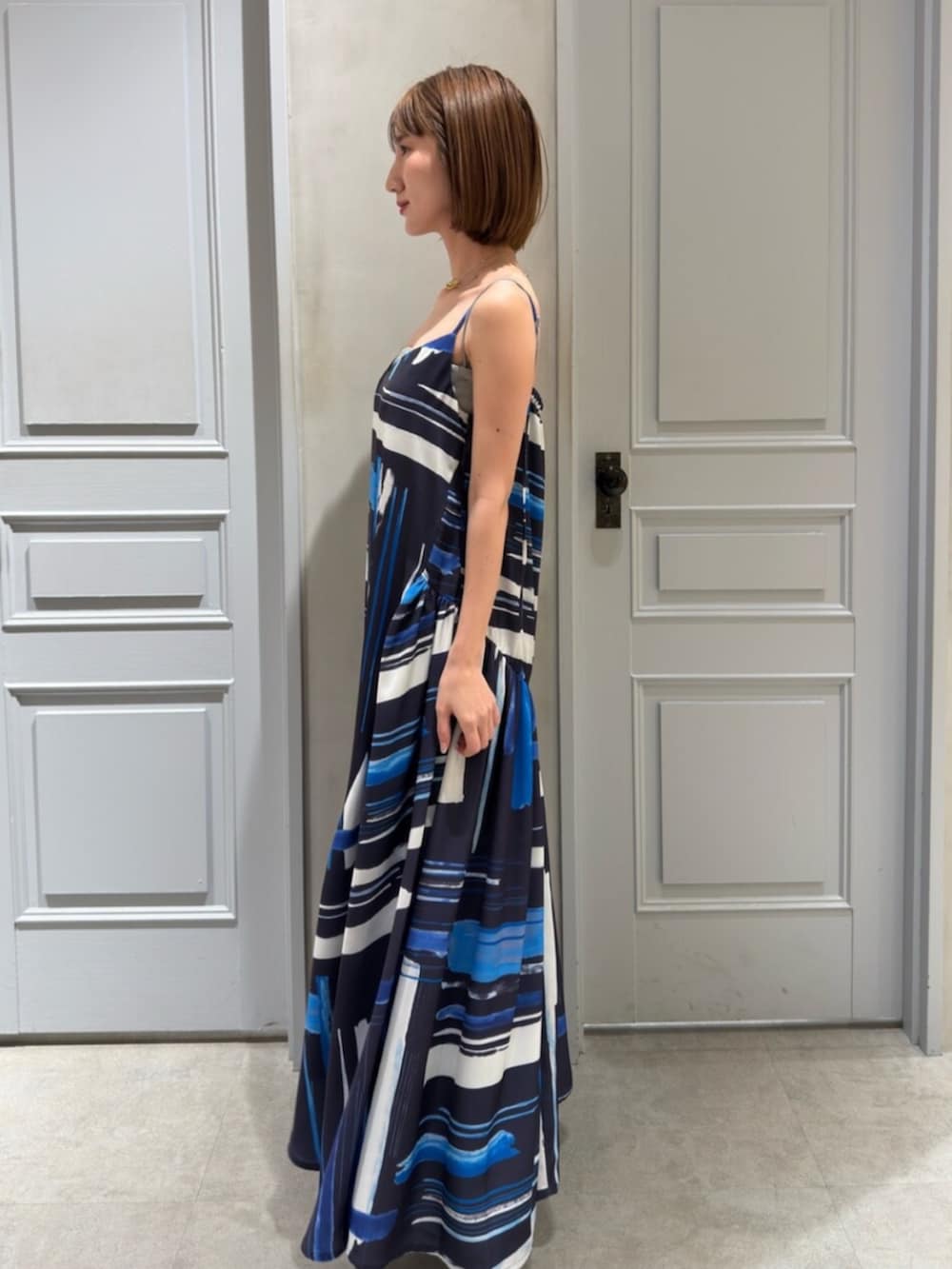 シルバー系のパンプス、ブルー系のワンピースを着用したレディースの冬コーディネートの2枚目の写真