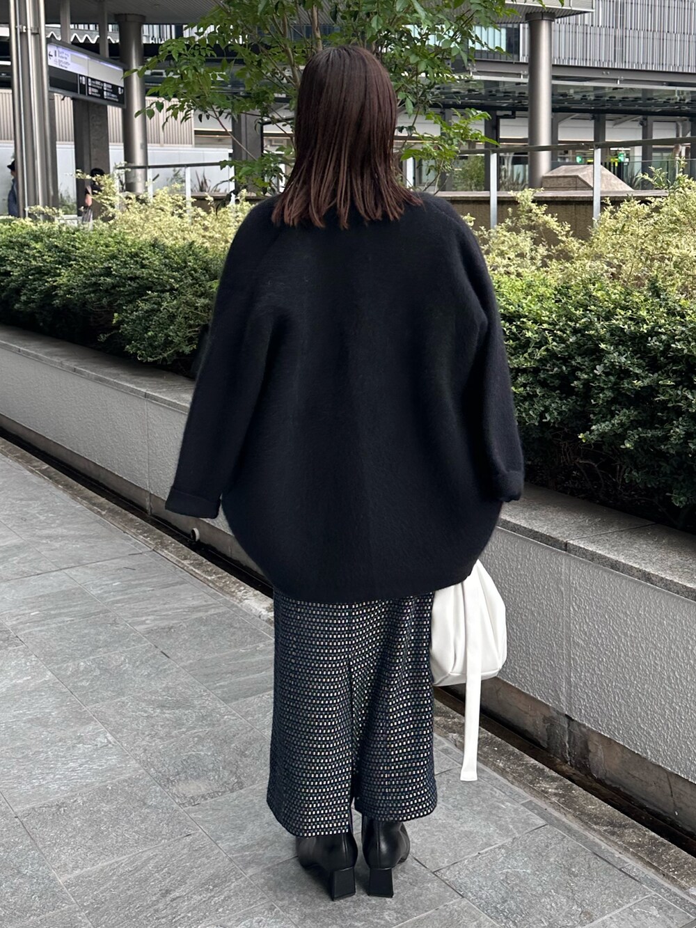 ブラック系のカーディガン/ボレロ、ブラック系のブーツ、ホワイト系のハンドバッグを着用したレディースの夏コーディネートの8枚目の写真