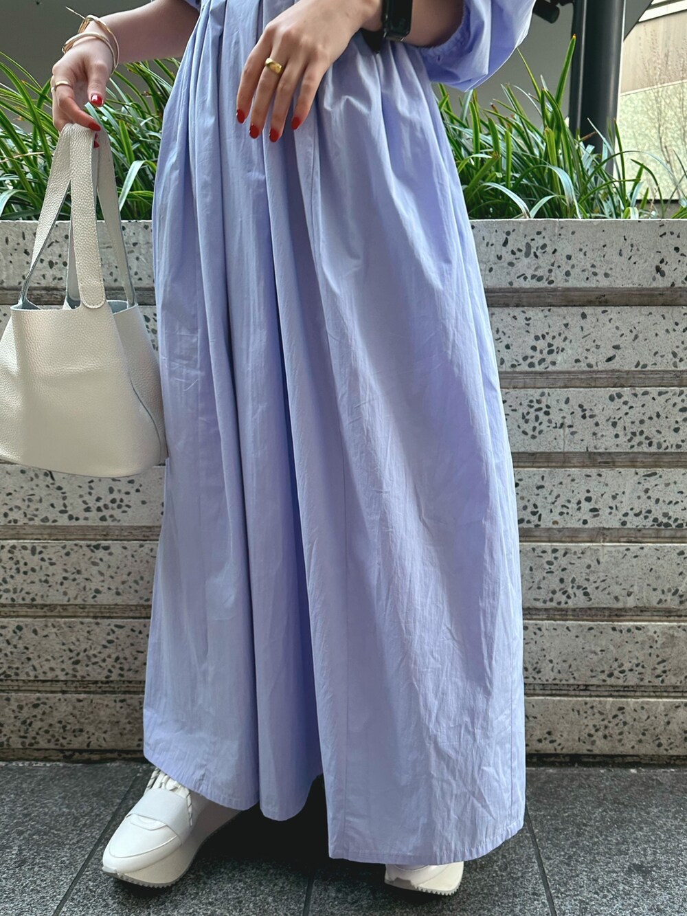 ホワイト系のハンドバッグ、ホワイト系のスニーカー、ブルー系のワンピースを着用したレディースの冬コーディネートの6枚目の写真