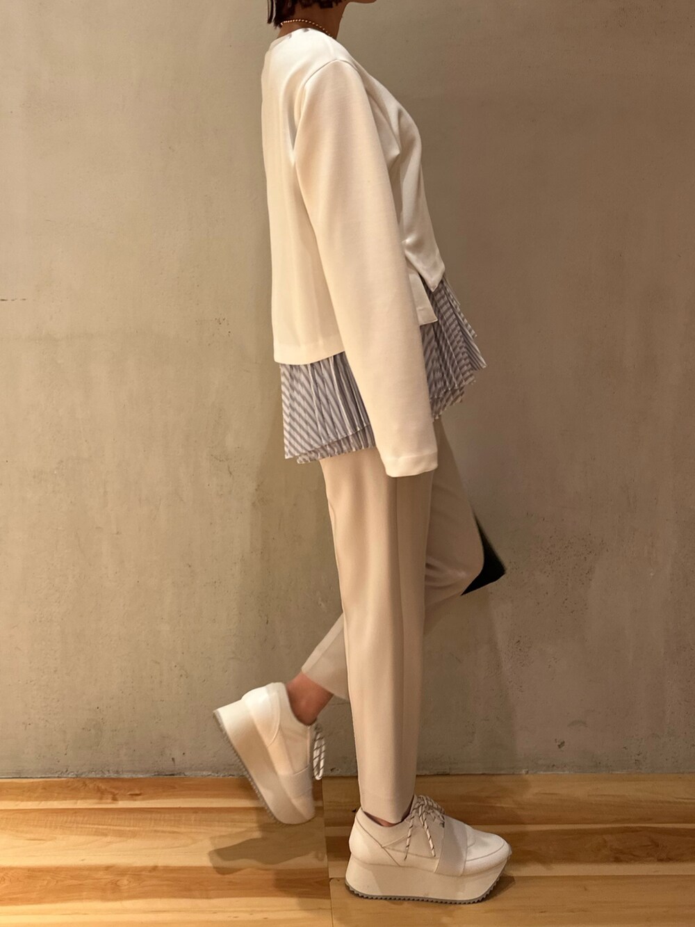 ホワイト系のスニーカー、ブラック系のハンドバッグ、グレー系のその他パンツを着用したレディースの冬コーディネートの3枚目の写真