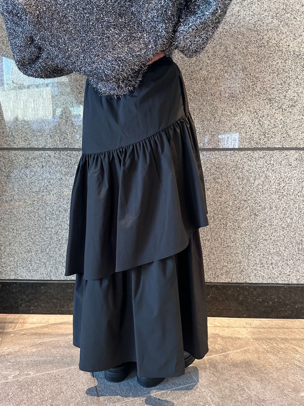 ブラック系のニット/セーター、ブラック系のスカートを着用したレディースの秋コーディネートの8枚目の写真