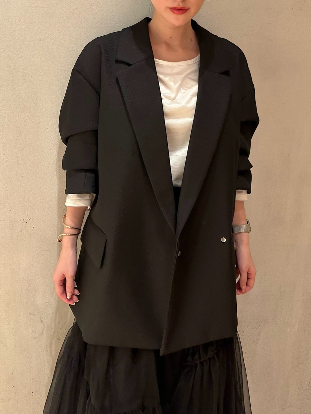 ブラック系のスカート、ブラック系のテーラードジャケット、ホワイト系のTシャツ/カットソーを着用したレディースの冬コーディネートの5枚目の写真