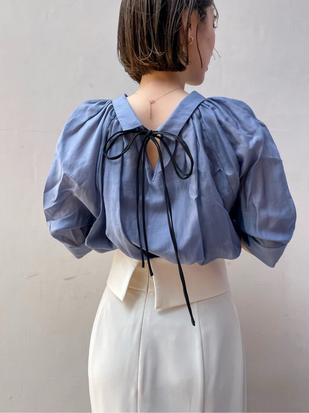 ホワイト系のスカート、ブラウン系のパンプス、ブルー系のシャツ/ブラウスを着用したレディースの春コーディネートの4枚目の写真