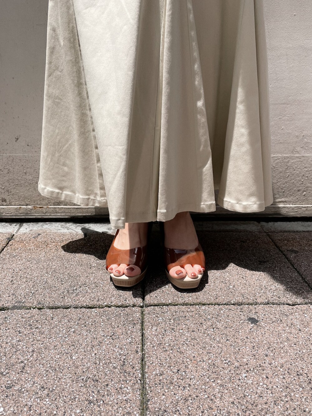 ブラウン系のパンプス、ホワイト系のスカート、ホワイト系のTシャツ/カットソーを着用したレディースの夏コーディネートの7枚目の写真