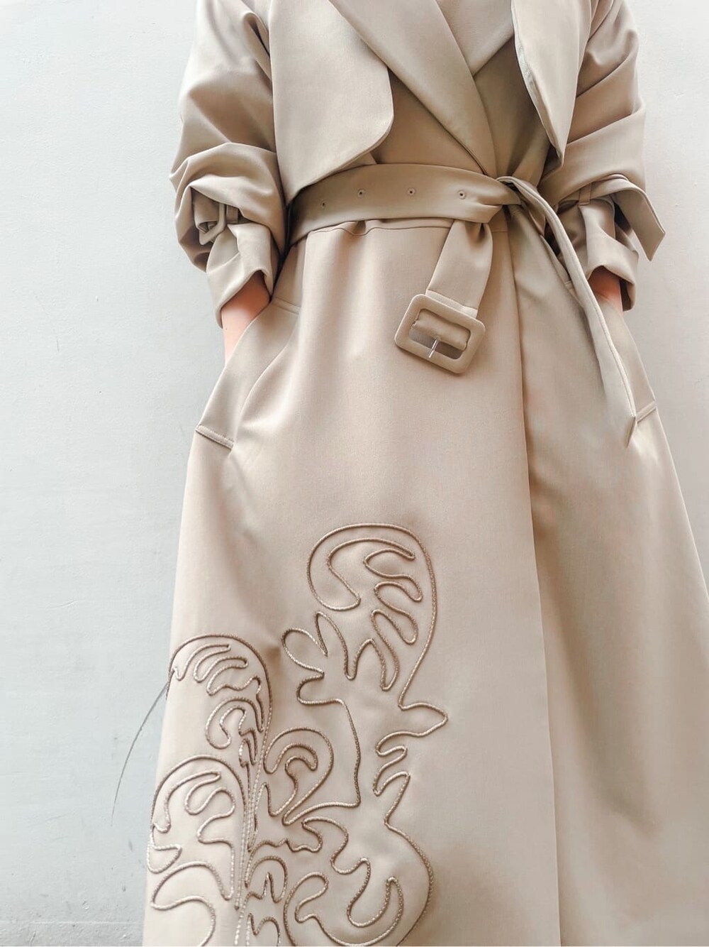 ベージュ系のトレンチコート、ブルー系のワンピース、ホワイト系のサンダルを着用したレディースの春コーディネートの6枚目の写真