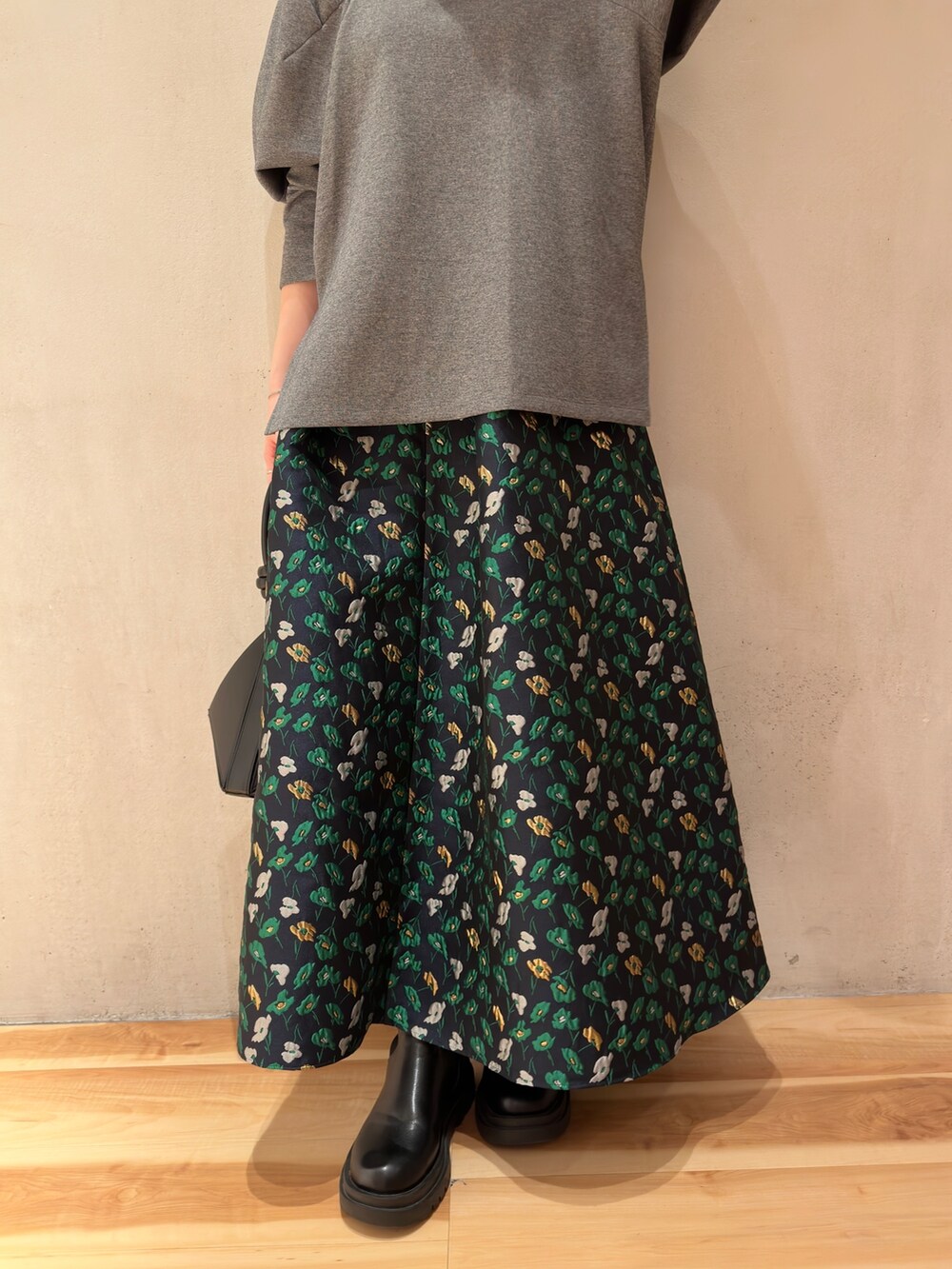 グレー系のTシャツ/カットソー、ブラック系のハンドバッグ、ブルー系のスカートを着用したレディースの春コーディネートの8枚目の写真