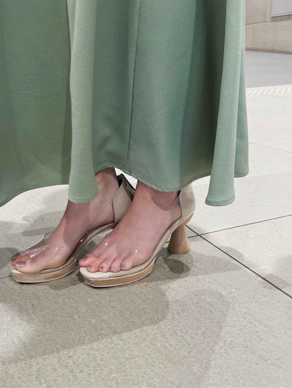 その他のパンプス、グリーン系のスカート、ホワイト系のハンドバッグを着用したレディースの冬コーディネートの4枚目の写真