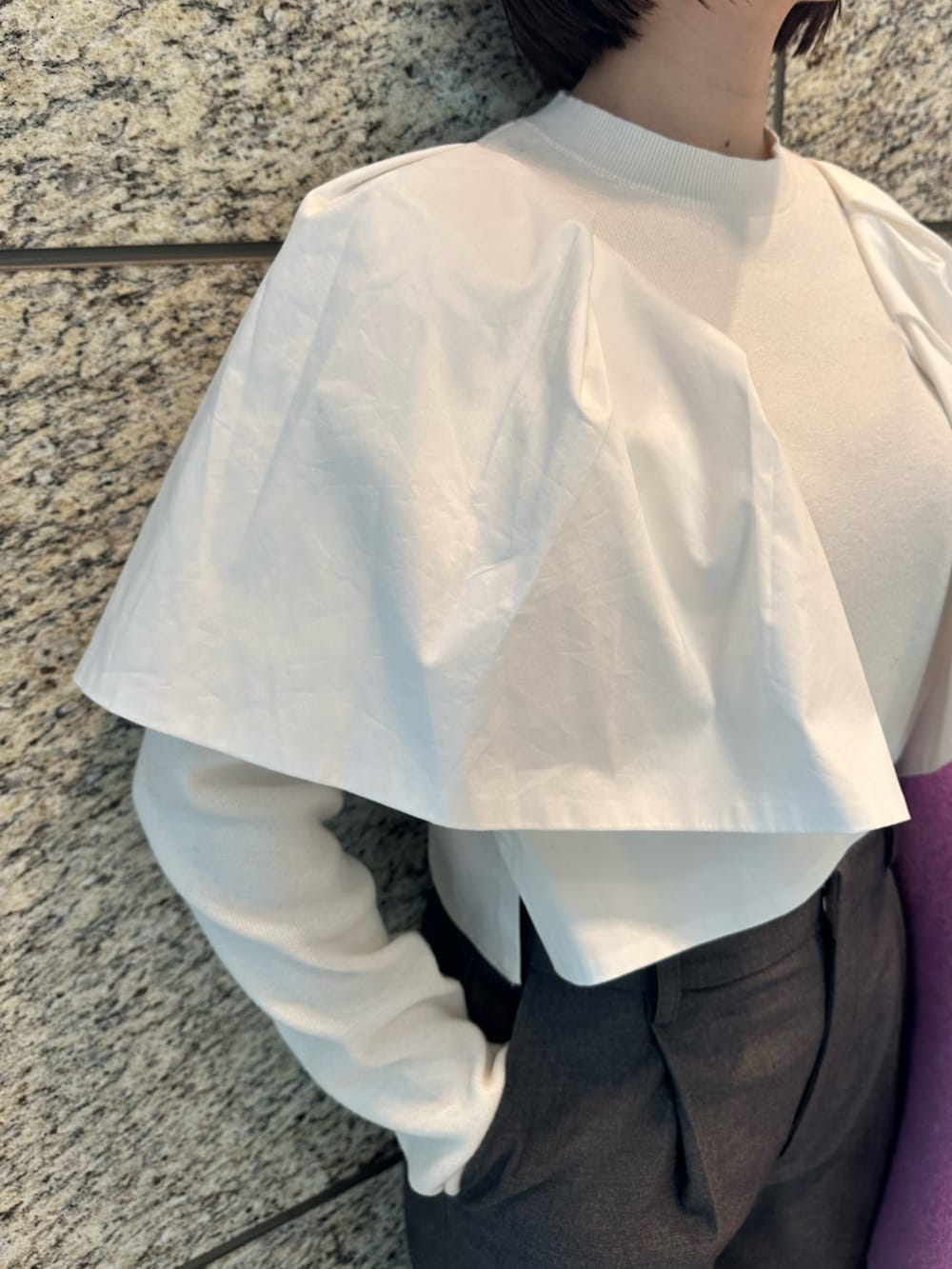 ホワイト系のニット/セーター、パープル系のノーカラージャケット、グレー系のその他パンツを着用したレディースの冬コーディネートの6枚目の写真