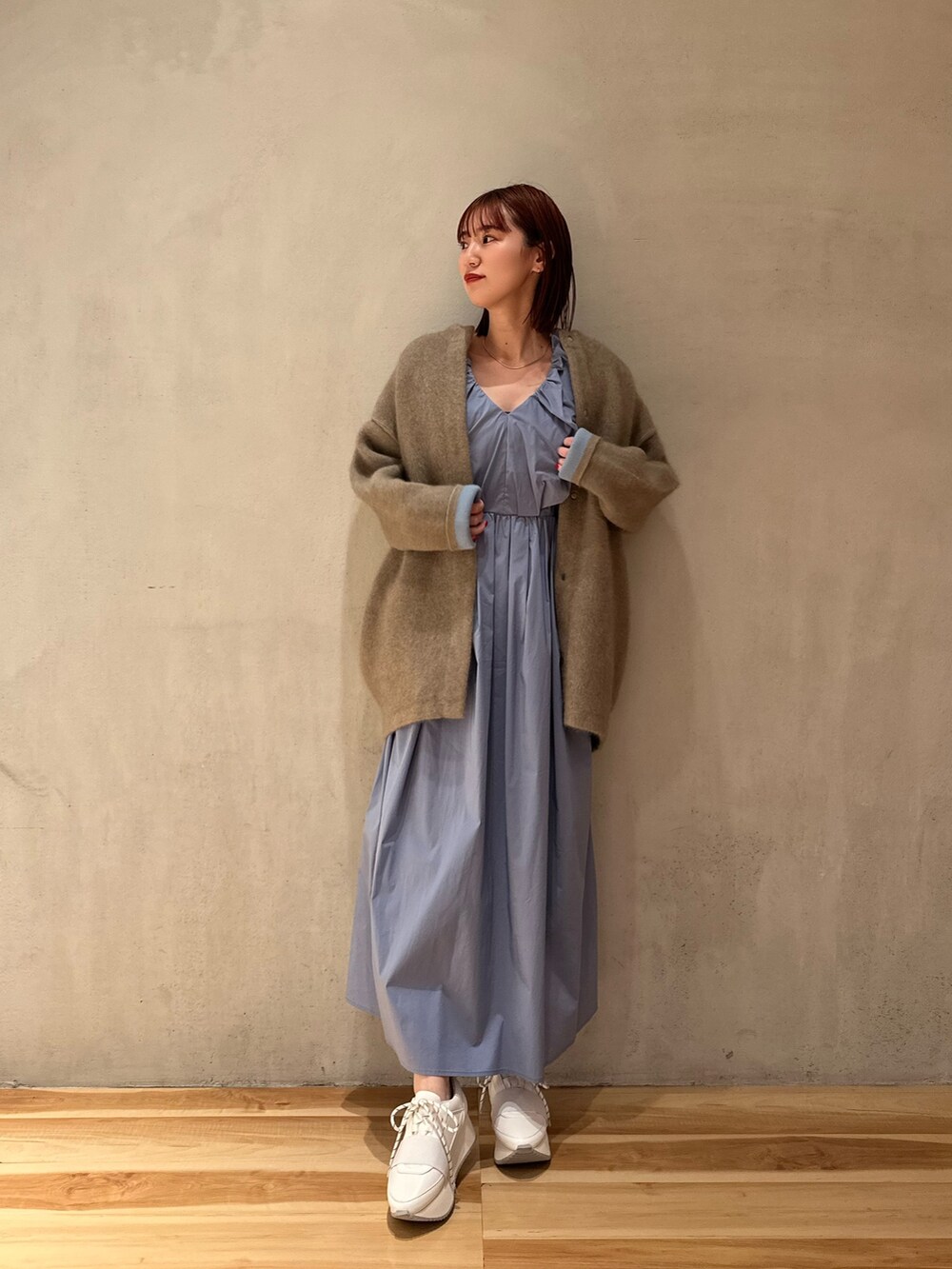 ブルー系のワンピース、ホワイト系のスニーカー、ベージュ系のノーカラージャケットを着用したレディースの夏コーディネートの2枚目の写真