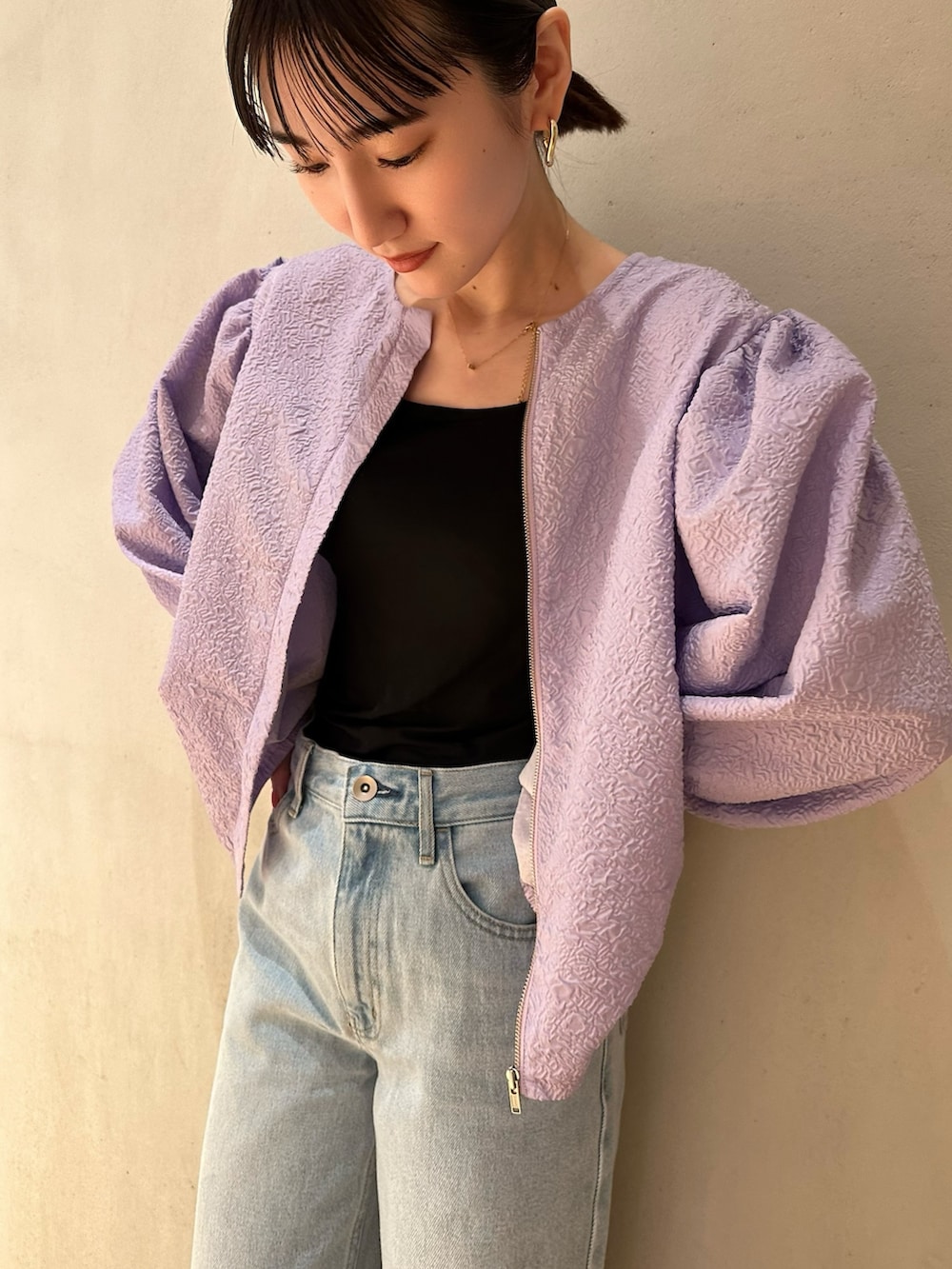 ブルー系のデニムパンツ、シルバー系のパンプス、パープル系のブルゾンを着用したレディースの冬コーディネートの3枚目の写真