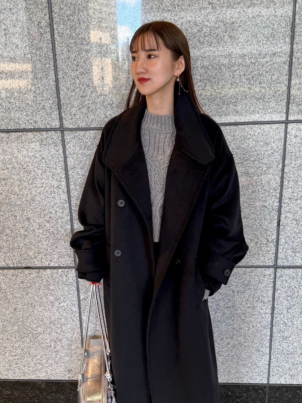 ブラック系のその他アウター、シルバー系のボストンバッグ、ブラック系のブーツを着用したレディースの冬コーディネートの6枚目の写真