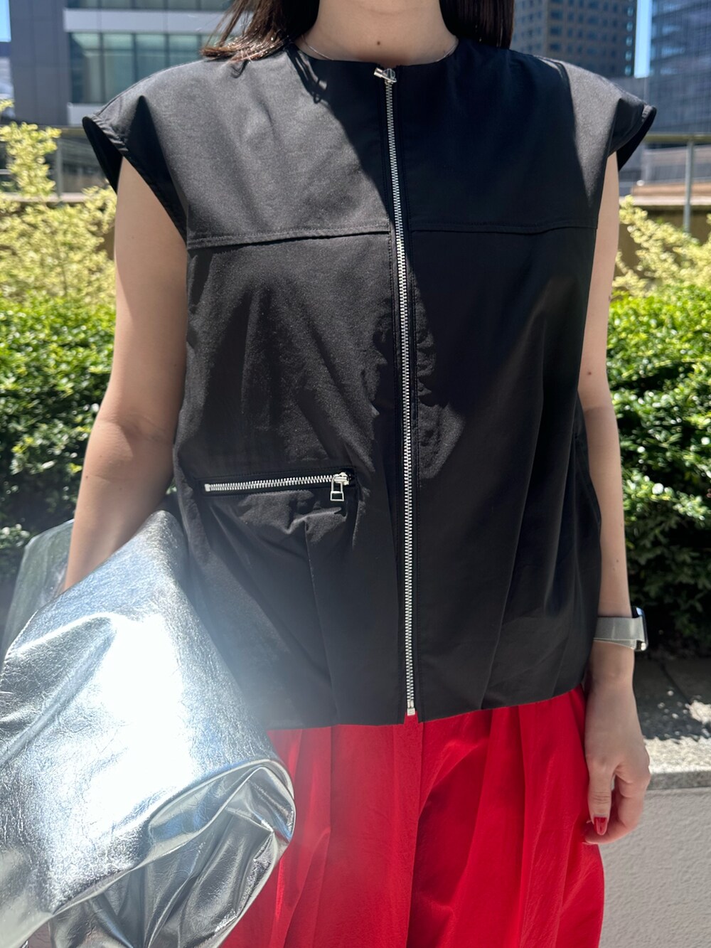レッド系のスカート、シルバー系のパンプス、シルバー系のトートバッグを着用したレディースの夏コーディネートの5枚目の写真