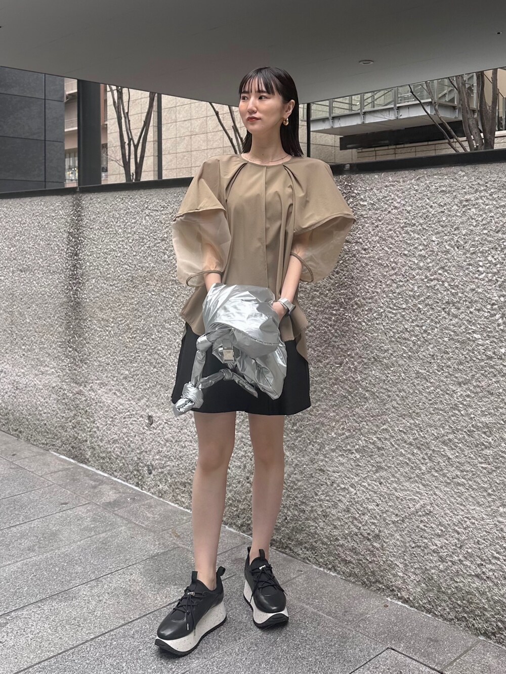 ベージュ系のシャツ/ブラウス、ブラック系のその他パンツ、シルバー系のショルダーバッグを着用したレディースの春コーディネートの3枚目の写真