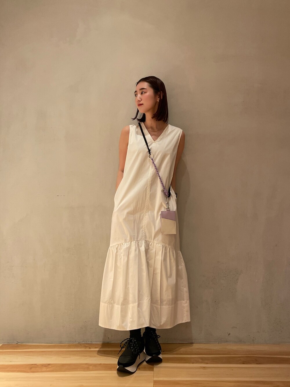 ホワイト系のワンピース、ブラック系のスニーカー、パープル系のスマホケース/カバーを着用したレディースの冬コーディネートの2枚目の写真