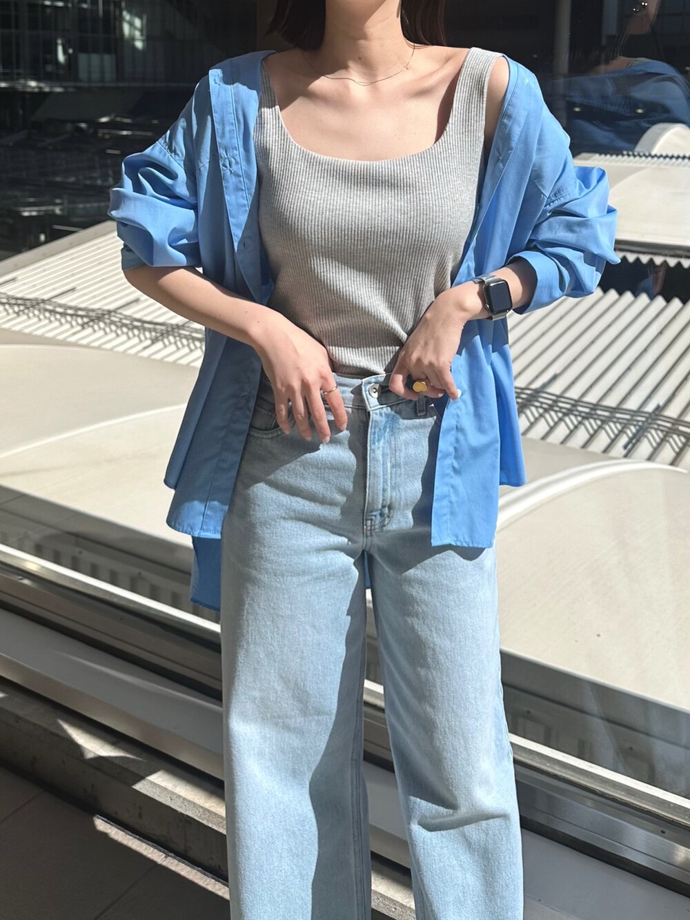 ブルー系のデニムパンツ、シルバー系のパンプス、グレー系のタンクトップを着用したレディースの春コーディネートの4枚目の写真