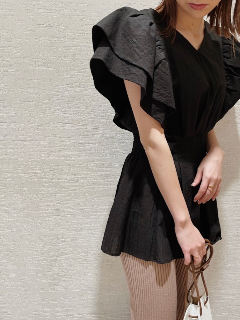 ホワイト系のハンドバッグ、ホワイト系のスニーカー、ブラック系のシャツ/ブラウスを着用したレディースの春コーディネートの2枚目の写真