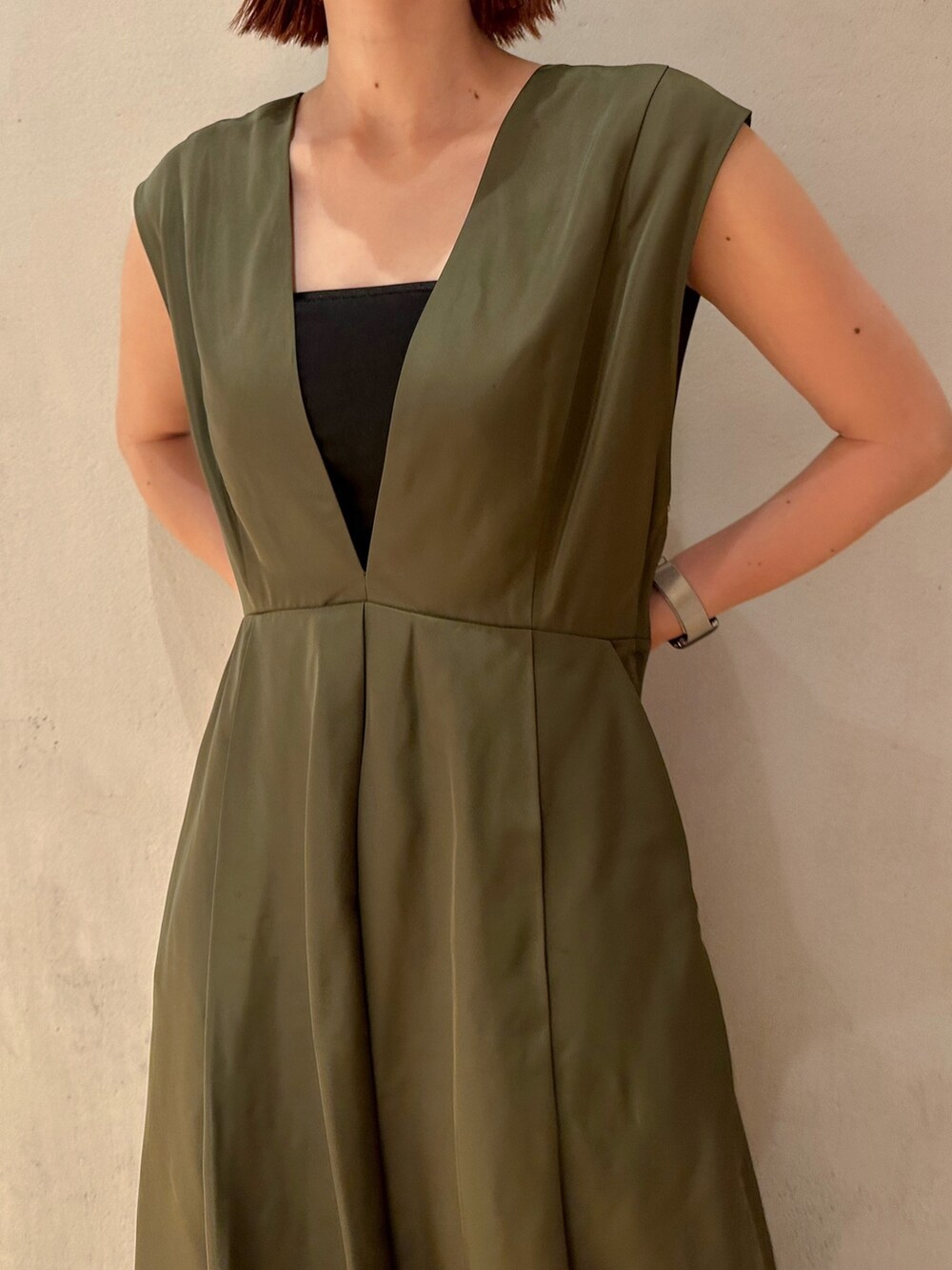 グリーン系のジャンパースカート、ブラック系のブーツを着用したレディースの夏コーディネートの4枚目の写真