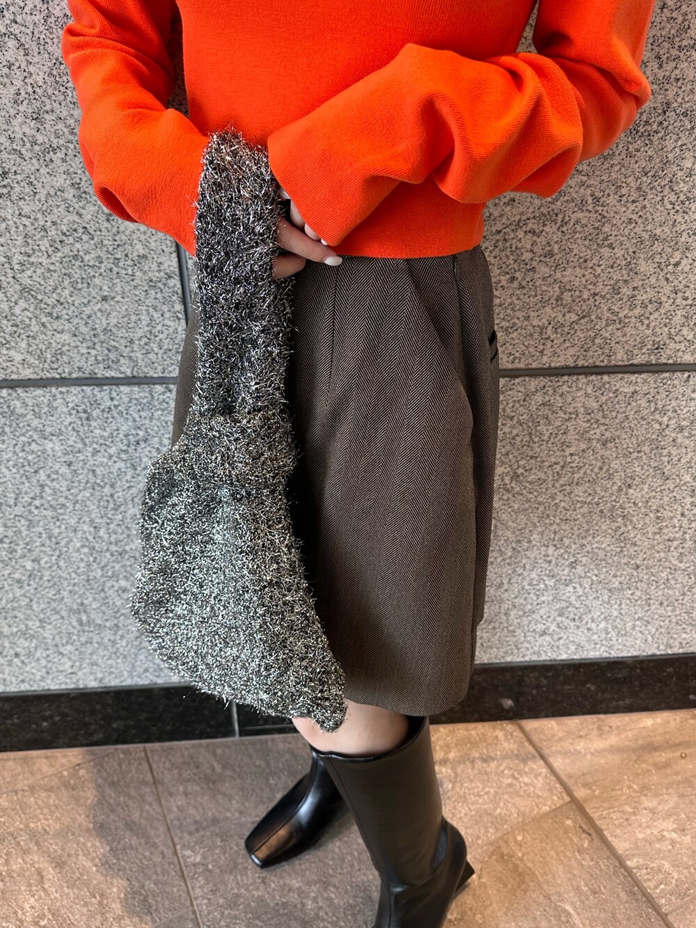 オレンジ系のニット/セーター、ブラウン系のテーラードジャケット、ブラウン系のスカートを着用したレディースの秋コーディネートの8枚目の写真