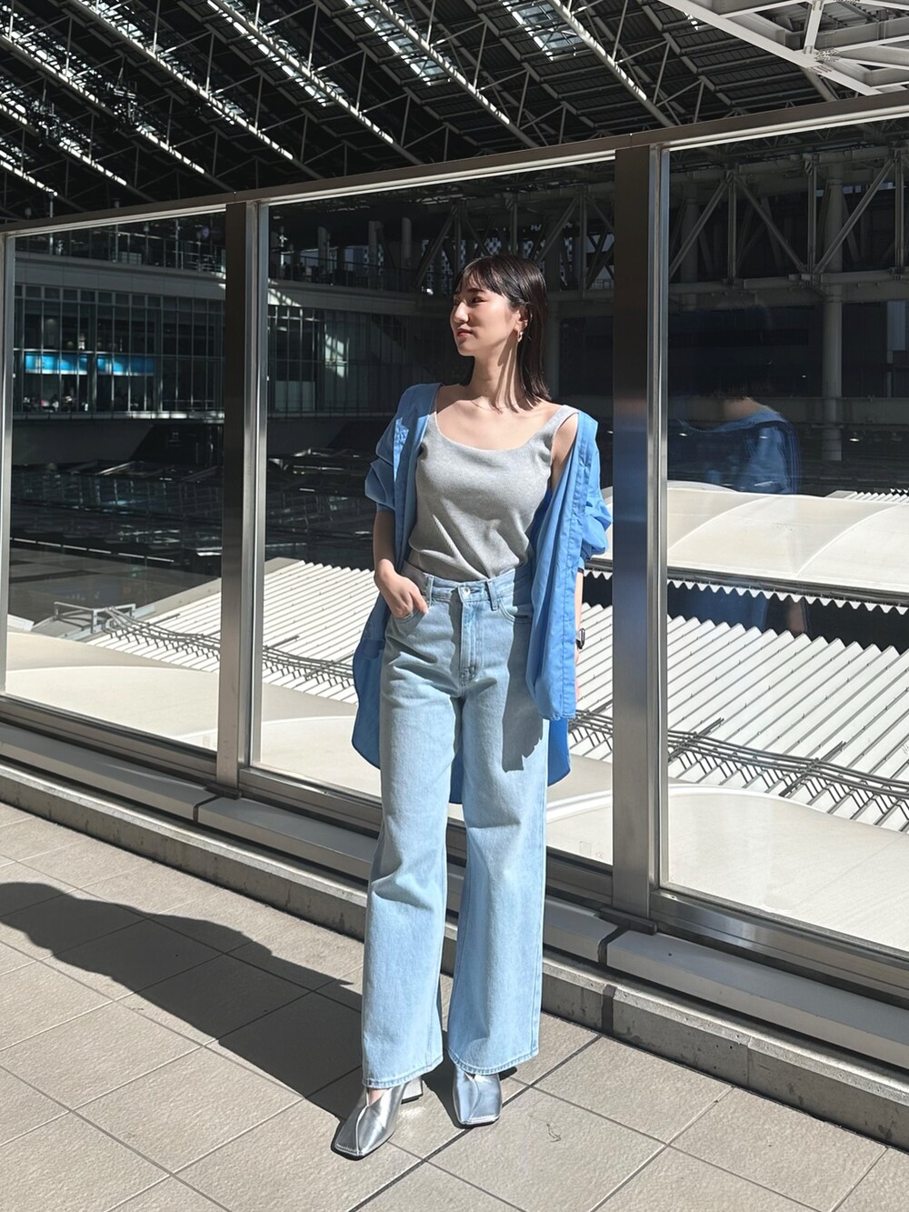 ブルー系のデニムパンツ、シルバー系のパンプス、グレー系のタンクトップを着用したレディースの春コーディネートの5枚目の写真