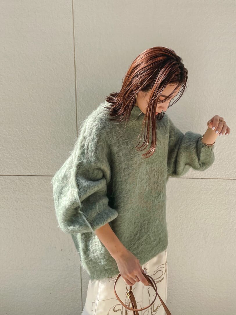 ベージュ系のブーツ、ブラウン系のショルダーバッグ、ホワイト系のスカートを着用したレディースの秋コーディネートの3枚目の写真