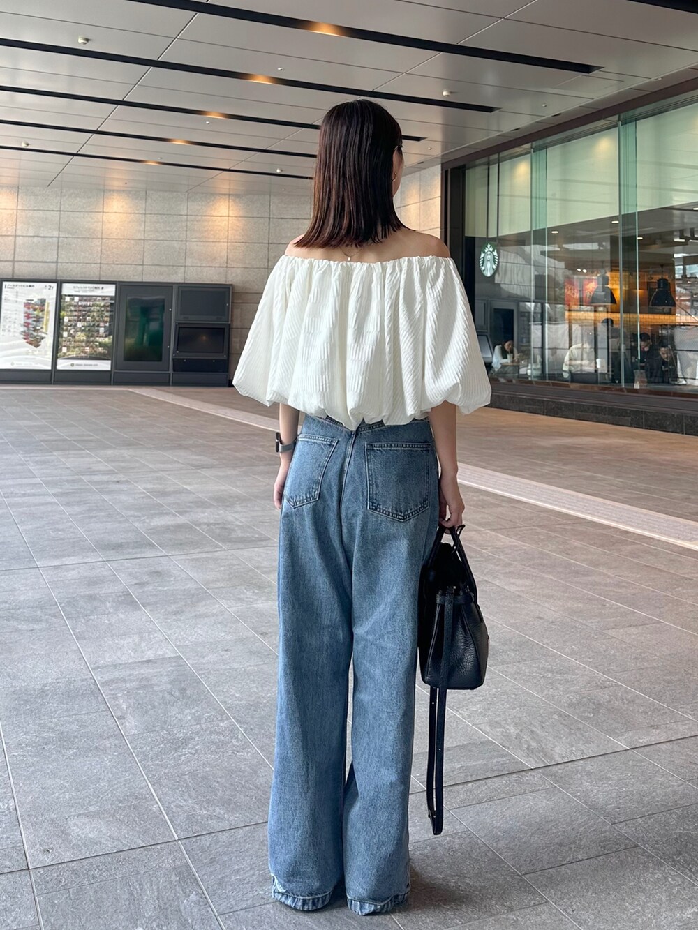 ホワイト系のシャツ/ブラウス、ブルー系のデニムパンツ、ブラック系のショルダーバッグを着用したレディースの夏コーディネートの2枚目の写真