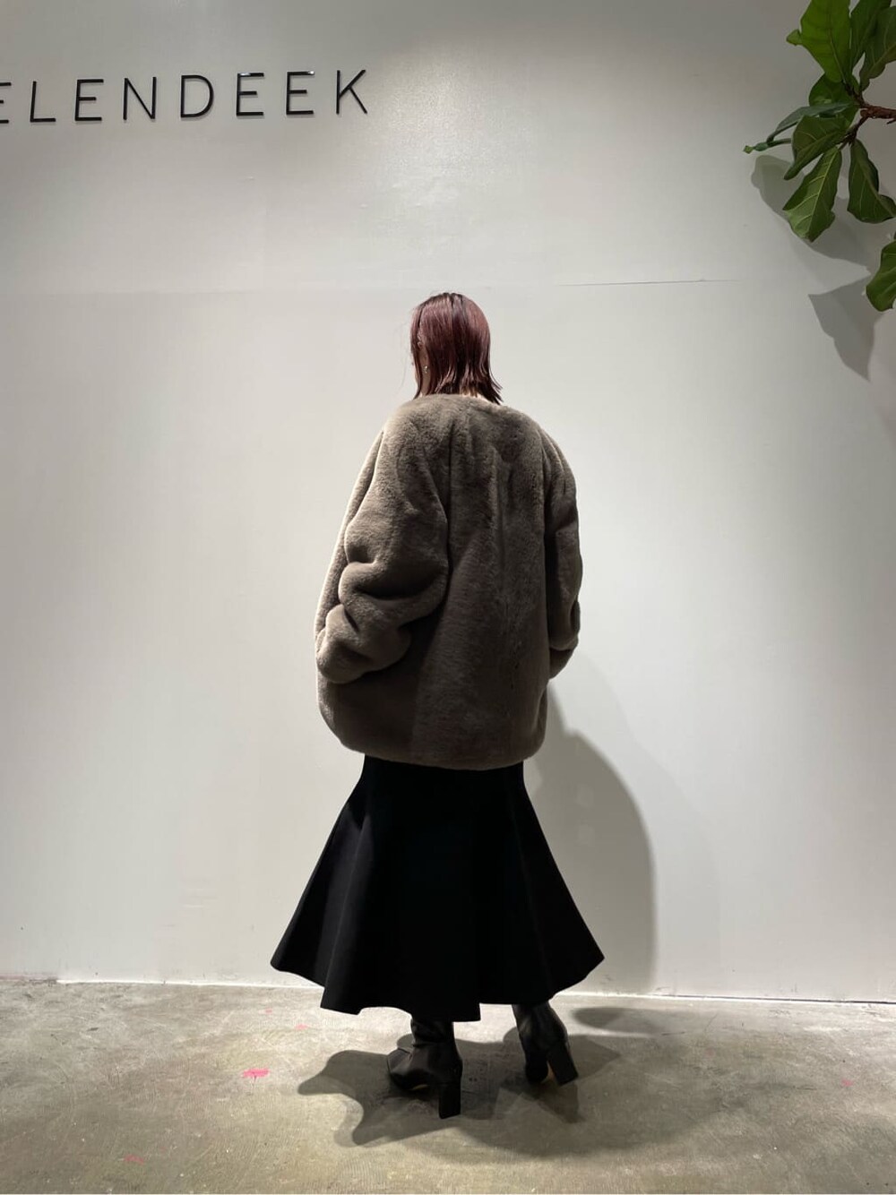 ベージュ系のニット/セーター、ブラウン系のノーカラーコート、ブラック系のブーツを着用したレディースの秋コーディネートの9枚目の写真