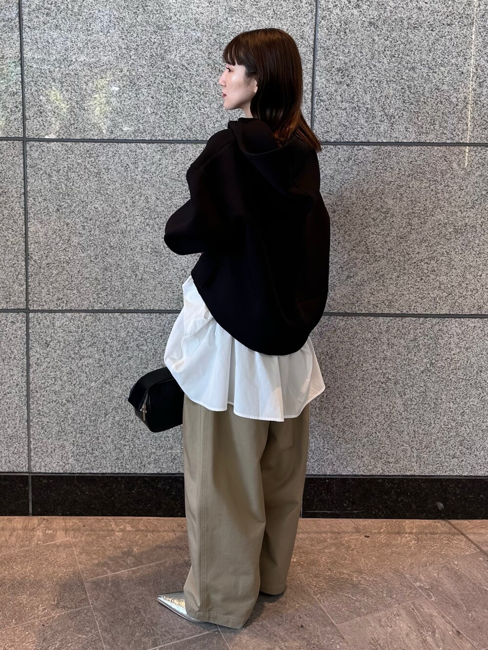 ベージュ系のその他パンツ、ブラック系のボストンバッグ、ブラック系のパーカーを着用したレディースの秋コーディネートの4枚目の写真