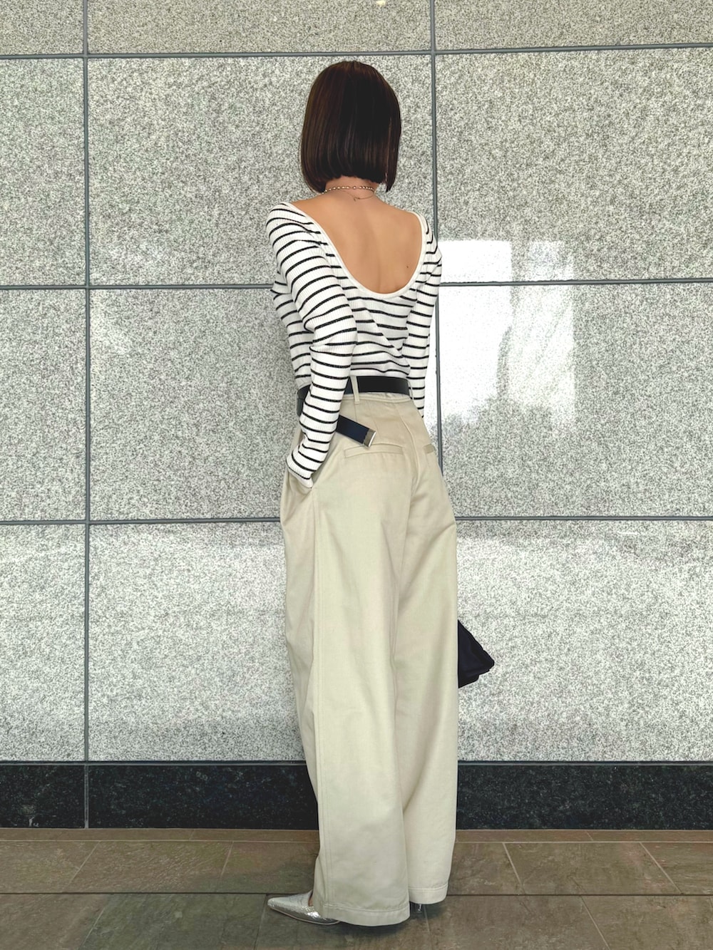 ホワイト系のその他パンツ、ブラック系のハンドバッグ、その他のニット/セーターを着用したレディースの春コーディネートの2枚目の写真