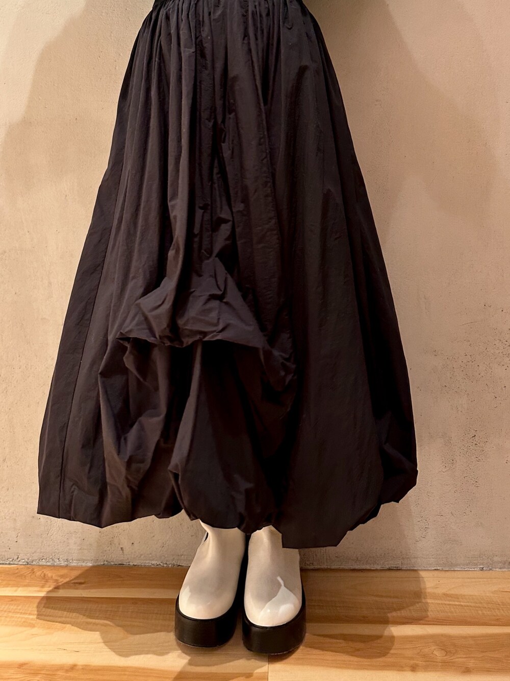 ブラック系のスカート、ブルー系のニット/セーター、ホワイト系のブーツを着用したレディースの冬コーディネートの6枚目の写真