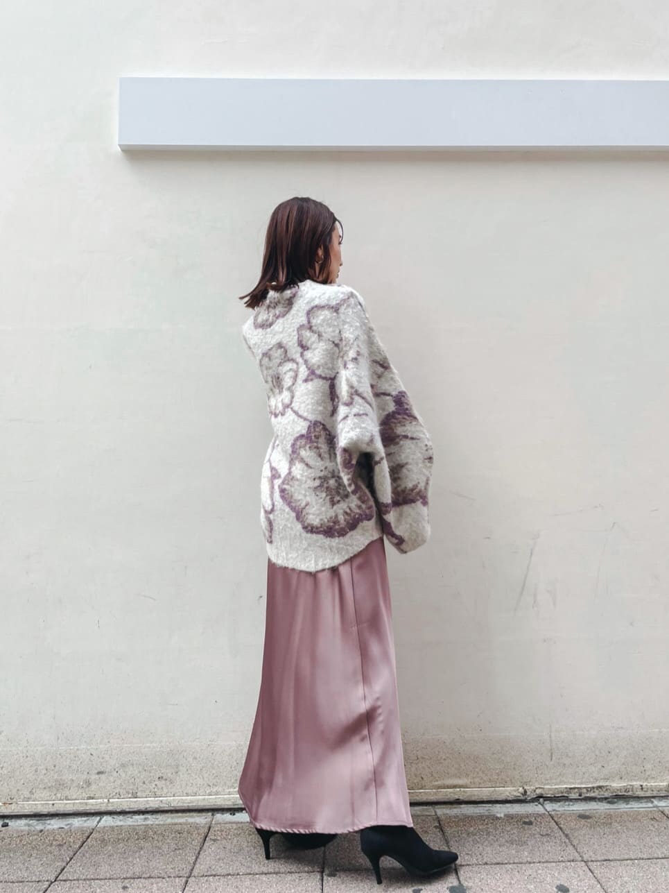 パープル系のスカート、ブラック系のブーツ、グレー系のニット/セーターを着用したレディースの秋コーディネートの2枚目の写真