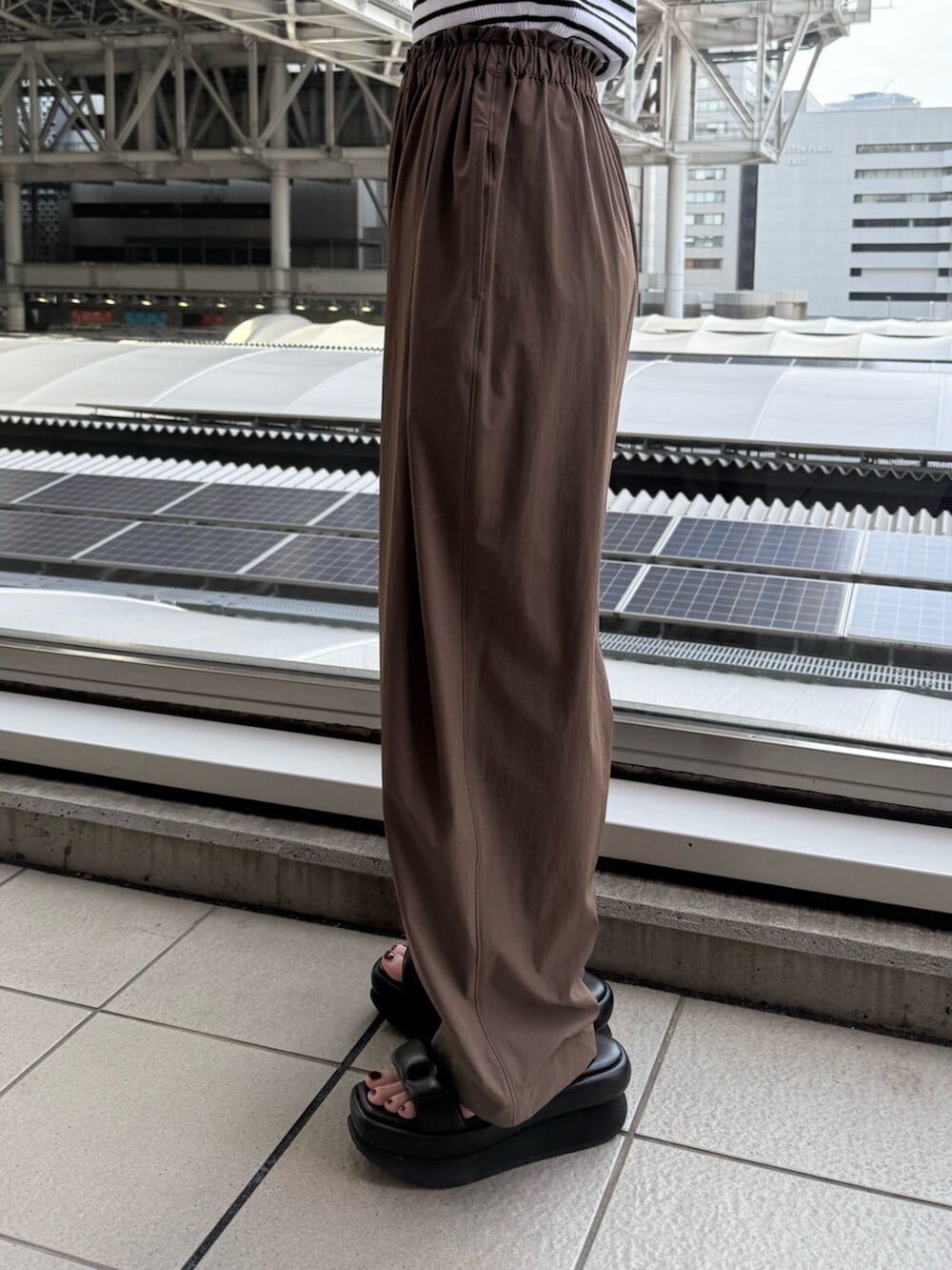 ブラック系のサンダル、ホワイト系のニット/セーター、ブラウン系のその他パンツを着用したレディースの夏コーディネートの8枚目の写真