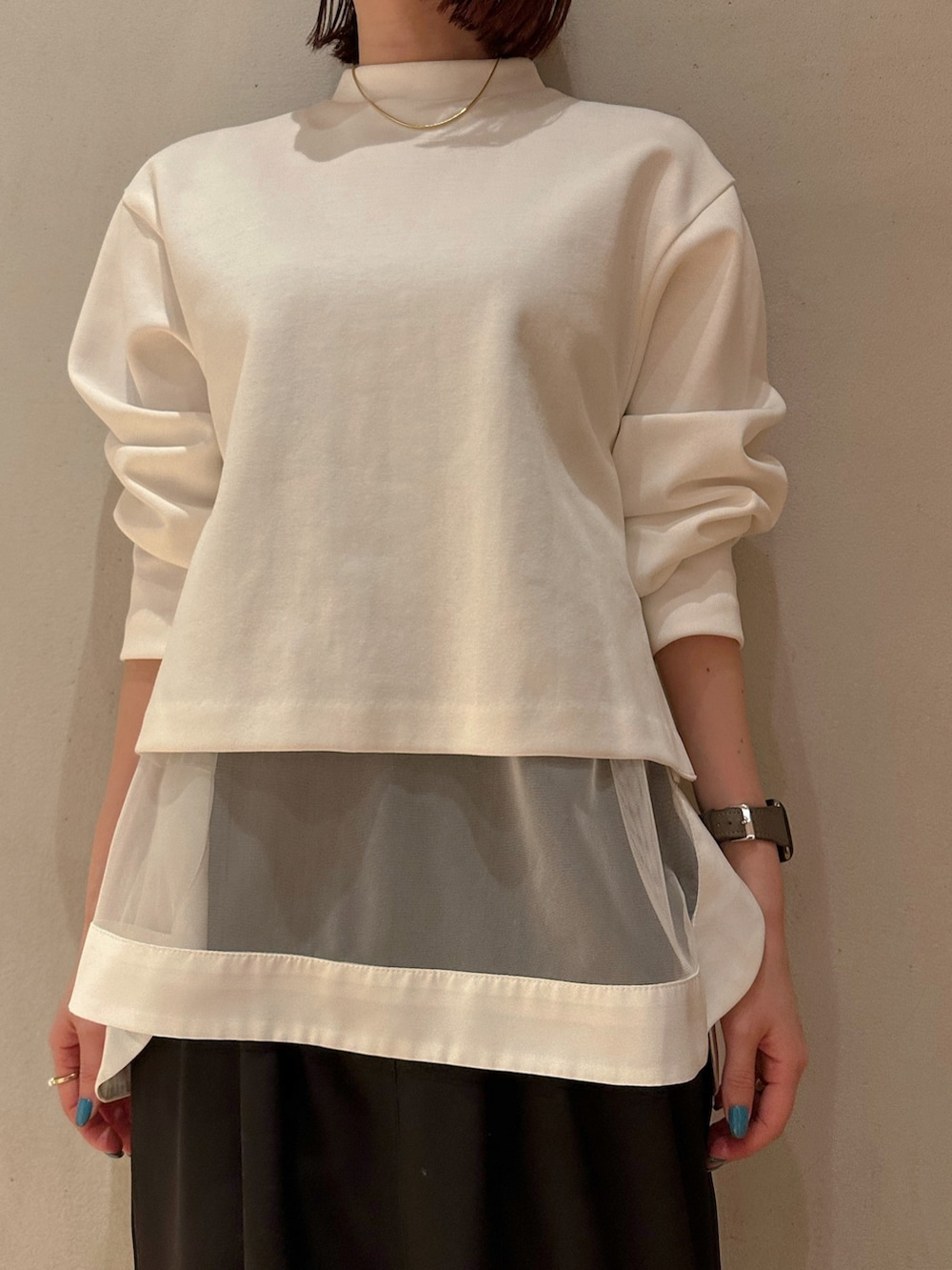 ホワイト系のTシャツ/カットソー、ブラック系のスカート、ブラック系のスニーカーを着用したレディースの冬コーディネートの3枚目の写真