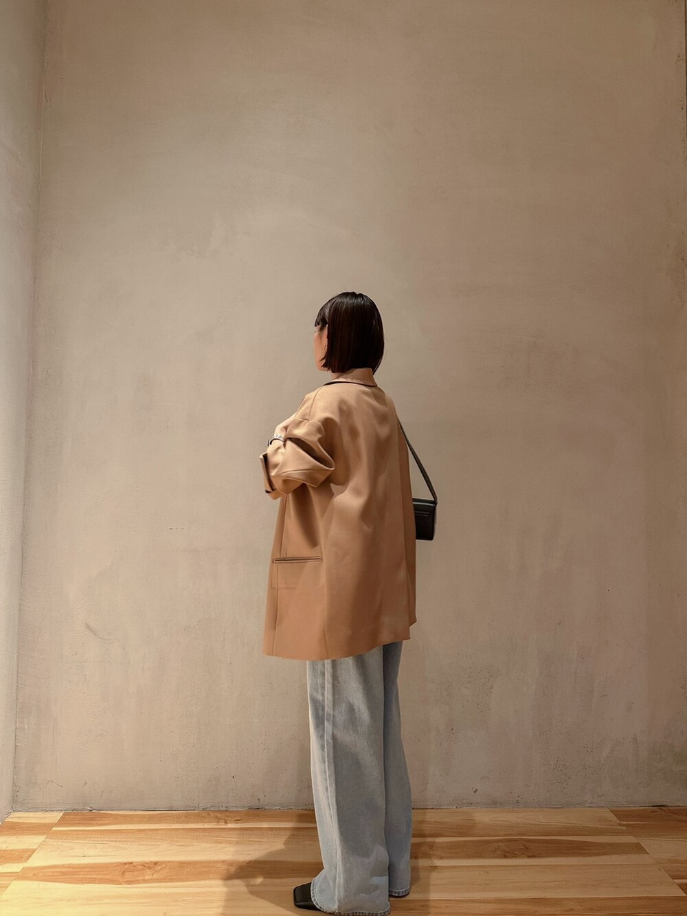 ブルー系のデニムパンツ、ブラック系のパンプス、ブラック系のショルダーバッグを着用したレディースの冬コーディネートの6枚目の写真