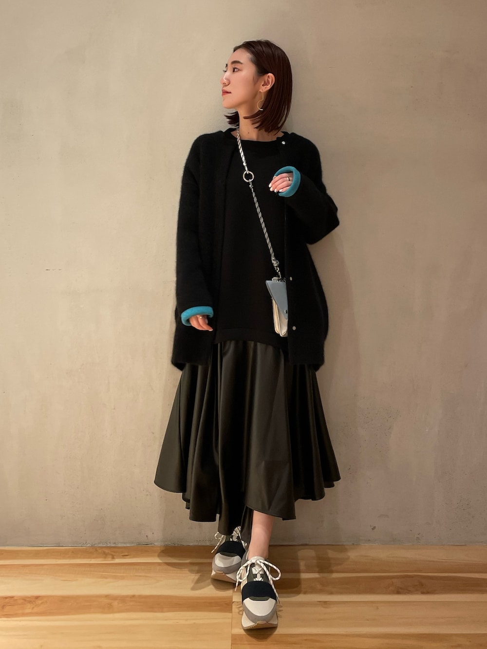 ブラック系のワンピース、グレー系のショルダーバッグ、ブラック系のカーディガン/ボレロを着用したレディースの秋コーディネートの2枚目の写真