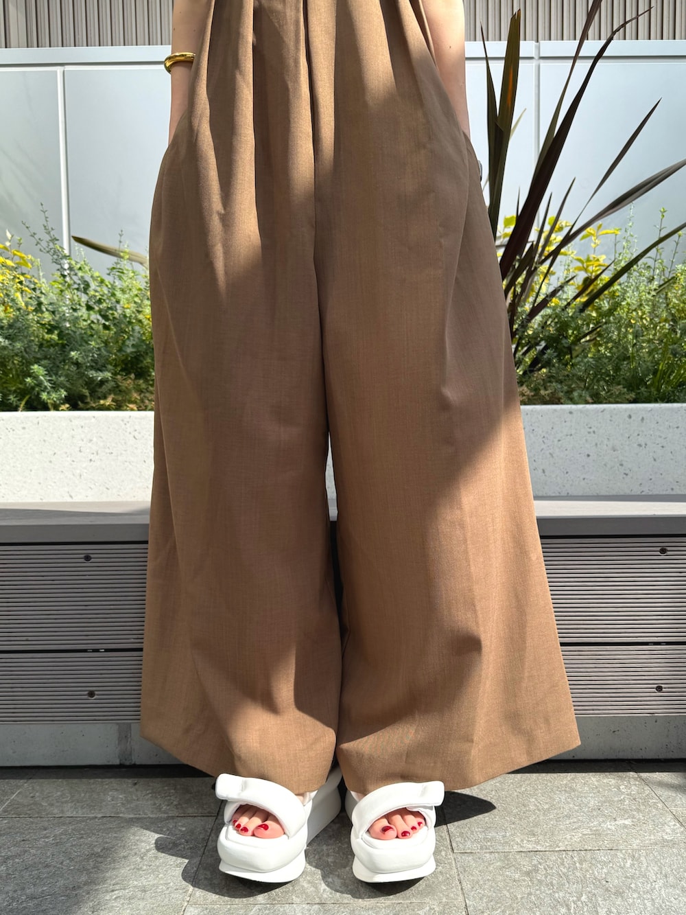 ブラック系のシャツ/ブラウス、ベージュ系のつなぎ/オールインワン、ホワイト系のサンダルを着用したレディースの春コーディネートの8枚目の写真