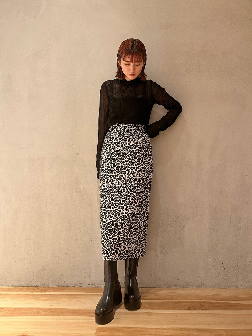 ブラック系のブーツ、ホワイト系のスカート、ブラック系のニット/セーターを着用したレディースの秋コーディネートの3枚目の写真