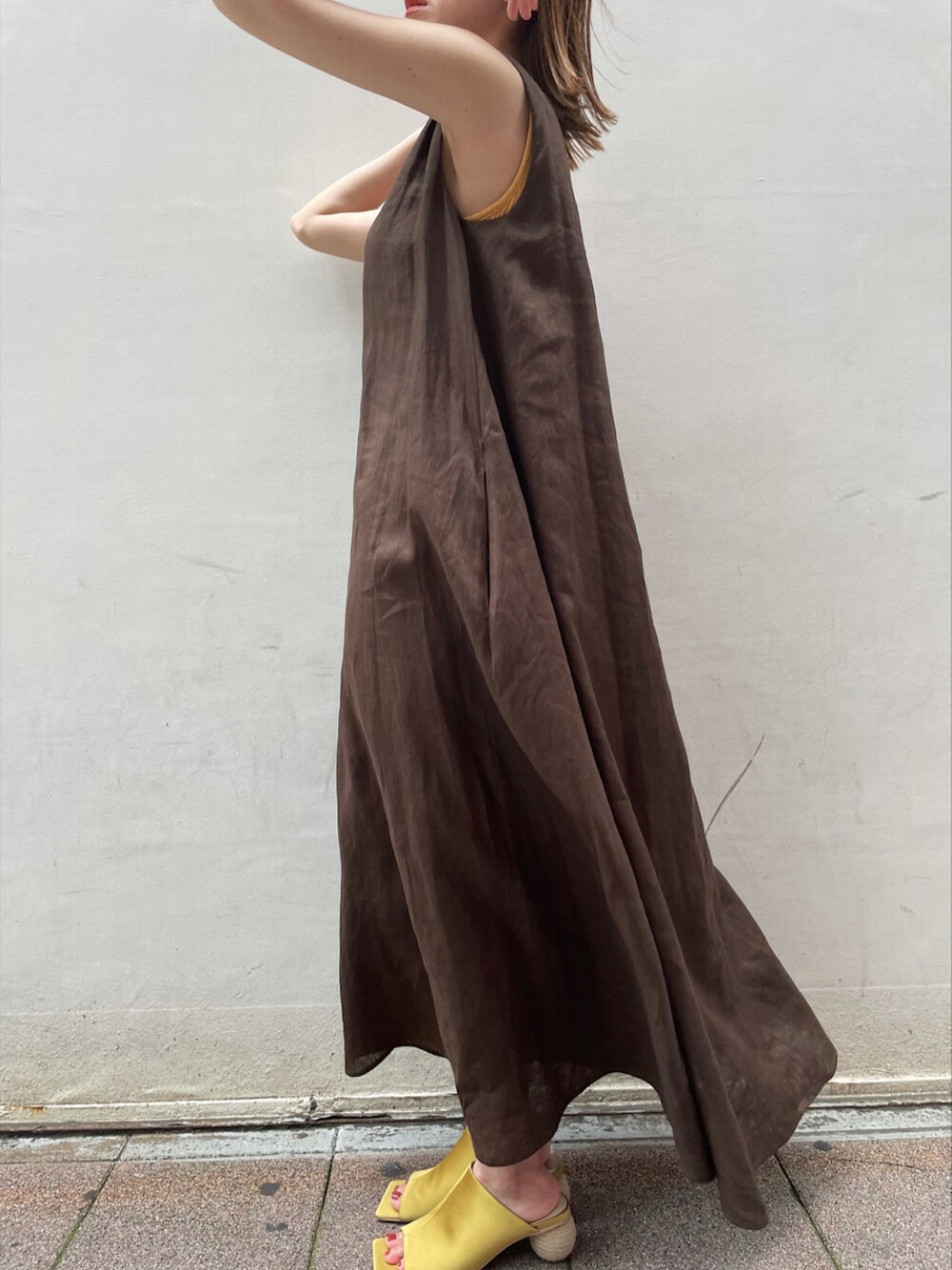 イエロー系のサンダル、ブラウン系のワンピース、ベージュ系のハットを着用したレディースの夏コーディネートの5枚目の写真