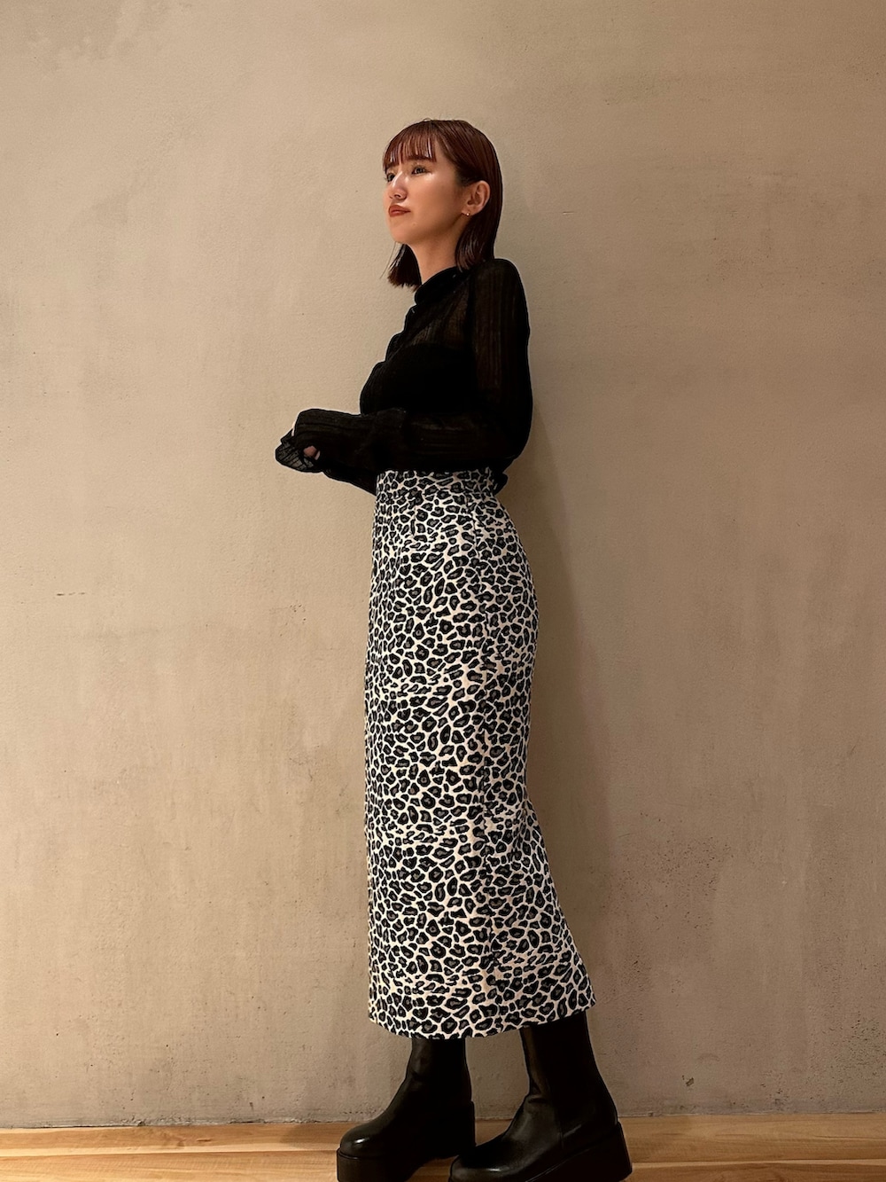 ブラック系のブーツ、ホワイト系のスカート、ブラック系のニット/セーターを着用したレディースの秋コーディネートの4枚目の写真