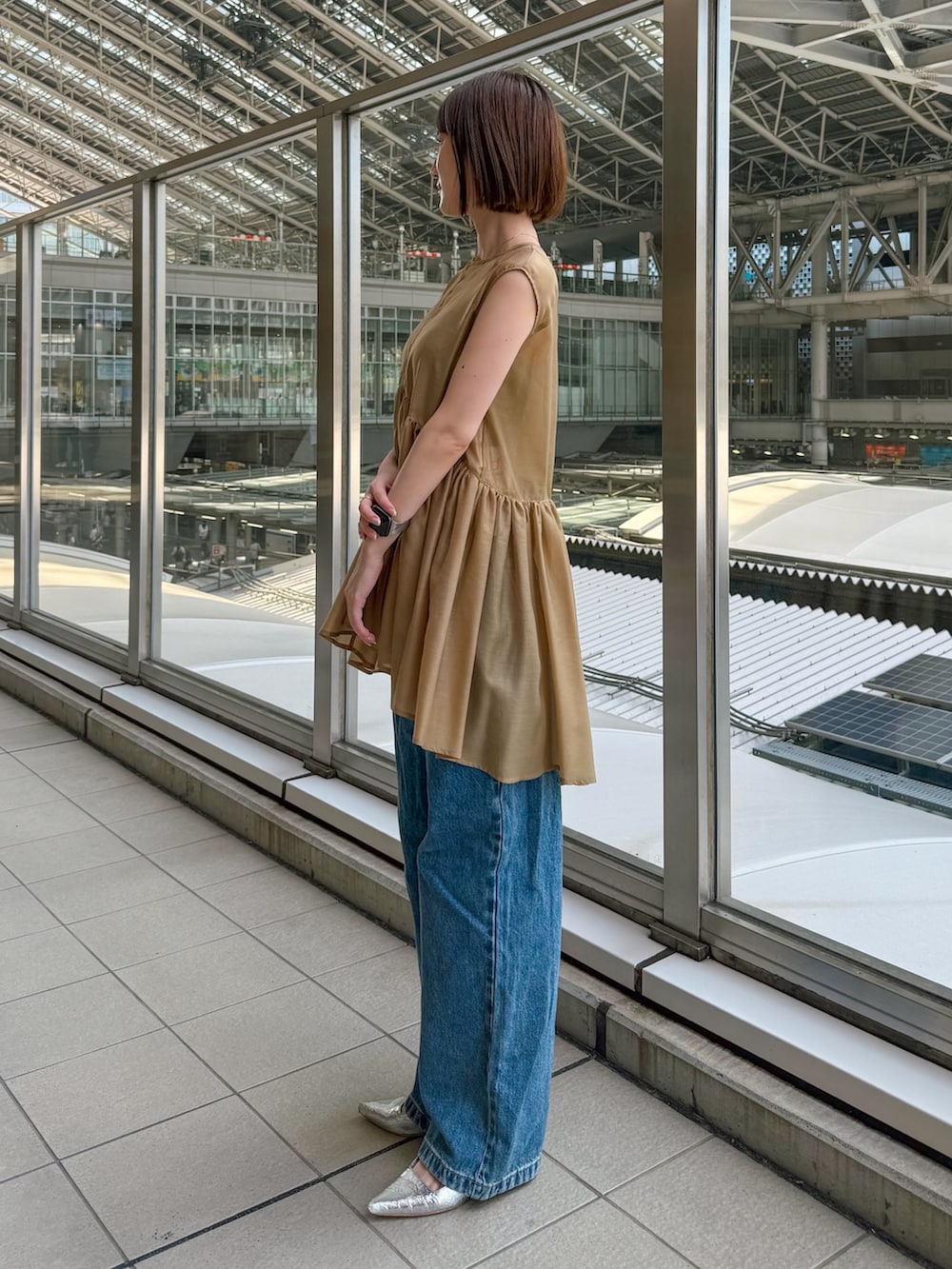 イエロー系のシャツ/ブラウス、ブルー系のデニムパンツを着用したレディースの夏コーディネートの2枚目の写真