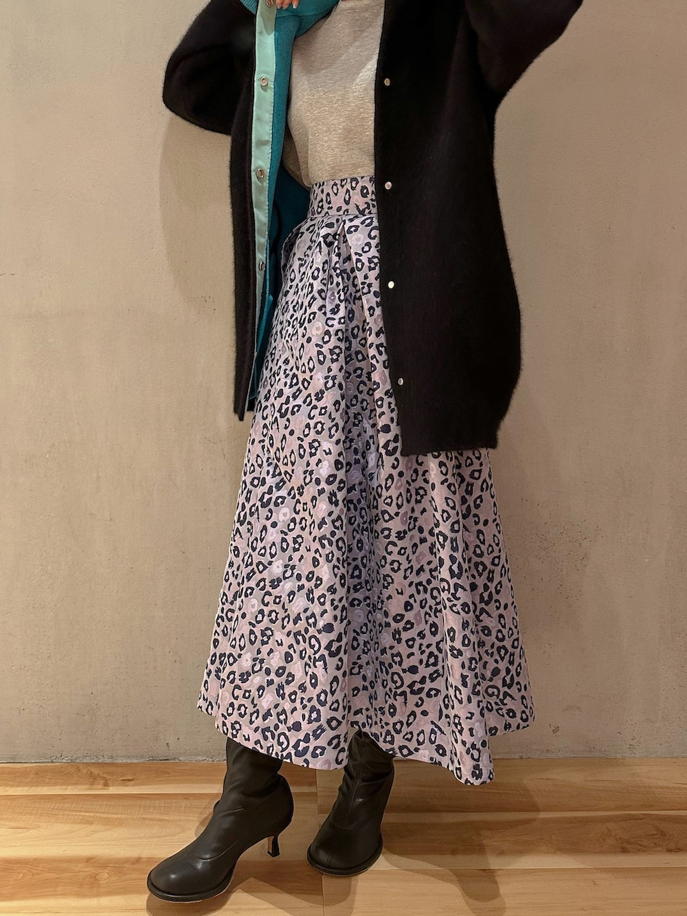 ブラック系のカーディガン/ボレロ、グレー系のTシャツ/カットソー、パープル系のスカートを着用したレディースの冬コーディネートの2枚目の写真