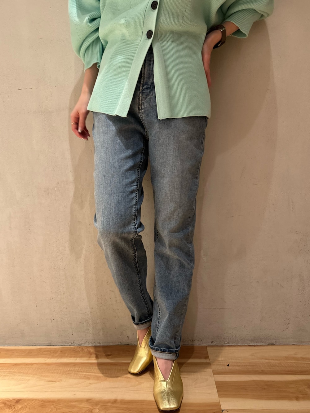 ブルー系のデニムパンツ、グリーン系のカーディガン/ボレロ、ホワイト系のTシャツ/カットソーを着用したレディースの冬コーディネートの6枚目の写真