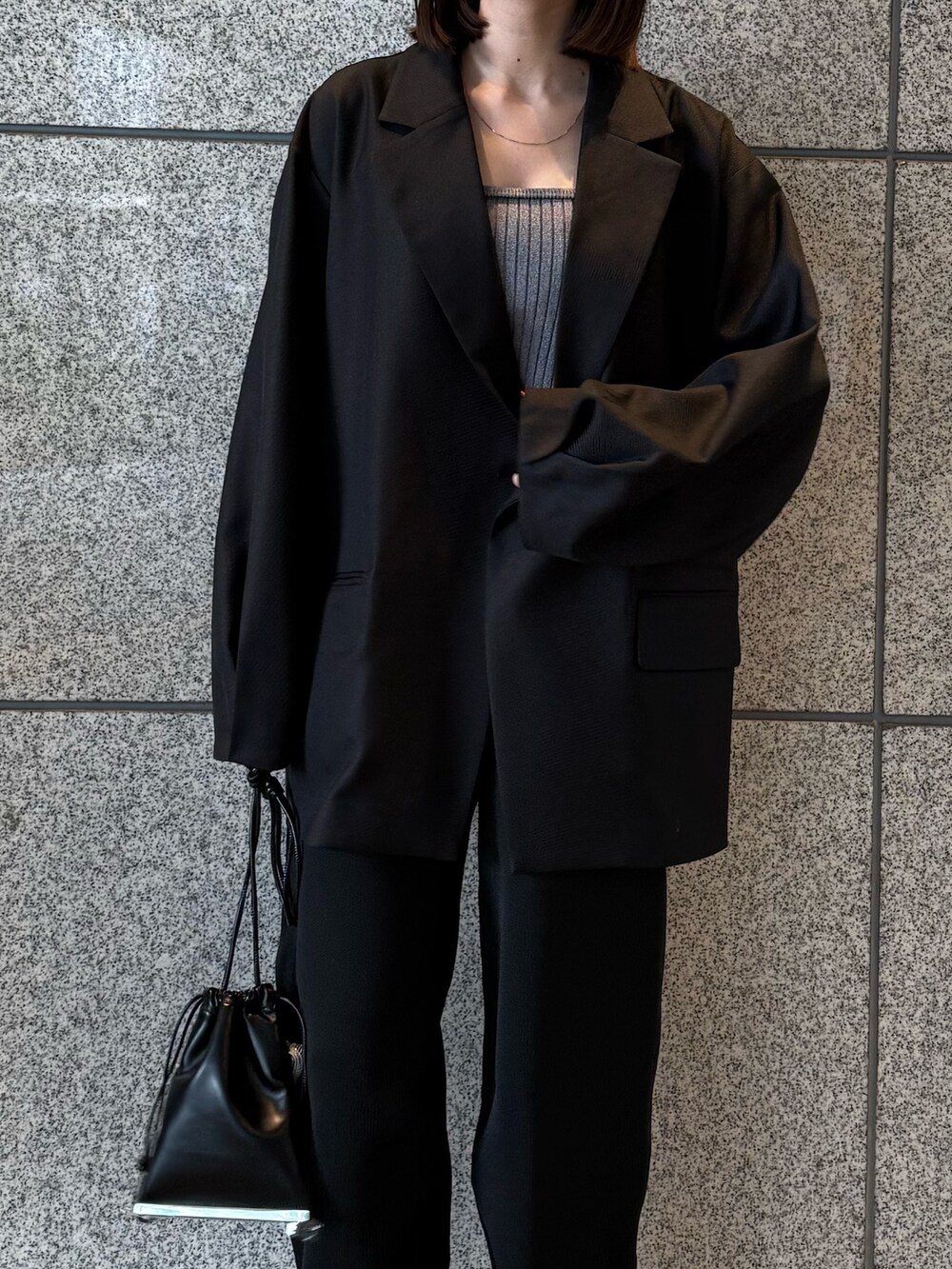 ブラック系のテーラードジャケット、ブラック系のその他パンツ、ブラック系のショルダーバッグを着用したレディースの冬コーディネートの6枚目の写真