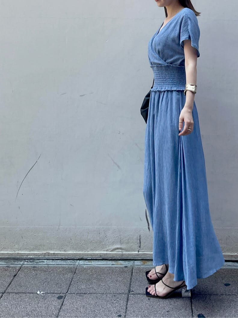 ブラック系のハンドバッグ、ブラック系のサンダル、ブルー系のワンピースを着用したレディースの夏コーディネートの2枚目の写真