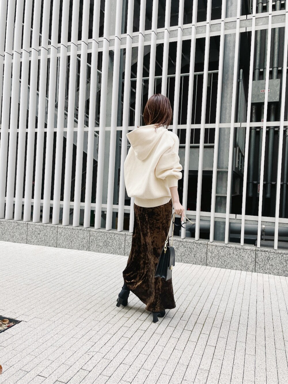 ブラウン系のスカート、ホワイト系のパーカーを着用したレディースの冬コーディネートの5枚目の写真