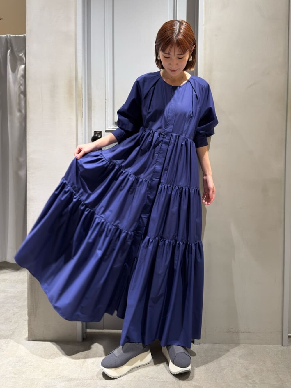 ブルー系のワンピース、グレー系のスニーカーを着用したレディースの秋コーディネートの2枚目の写真