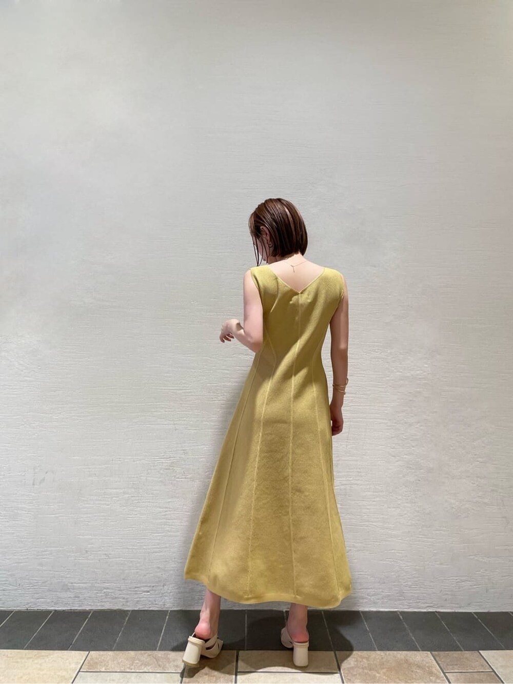 ホワイト系のサンダル、イエロー系のワンピース、ホワイト系のカーディガン/ボレロを着用したレディースの夏コーディネートの8枚目の写真