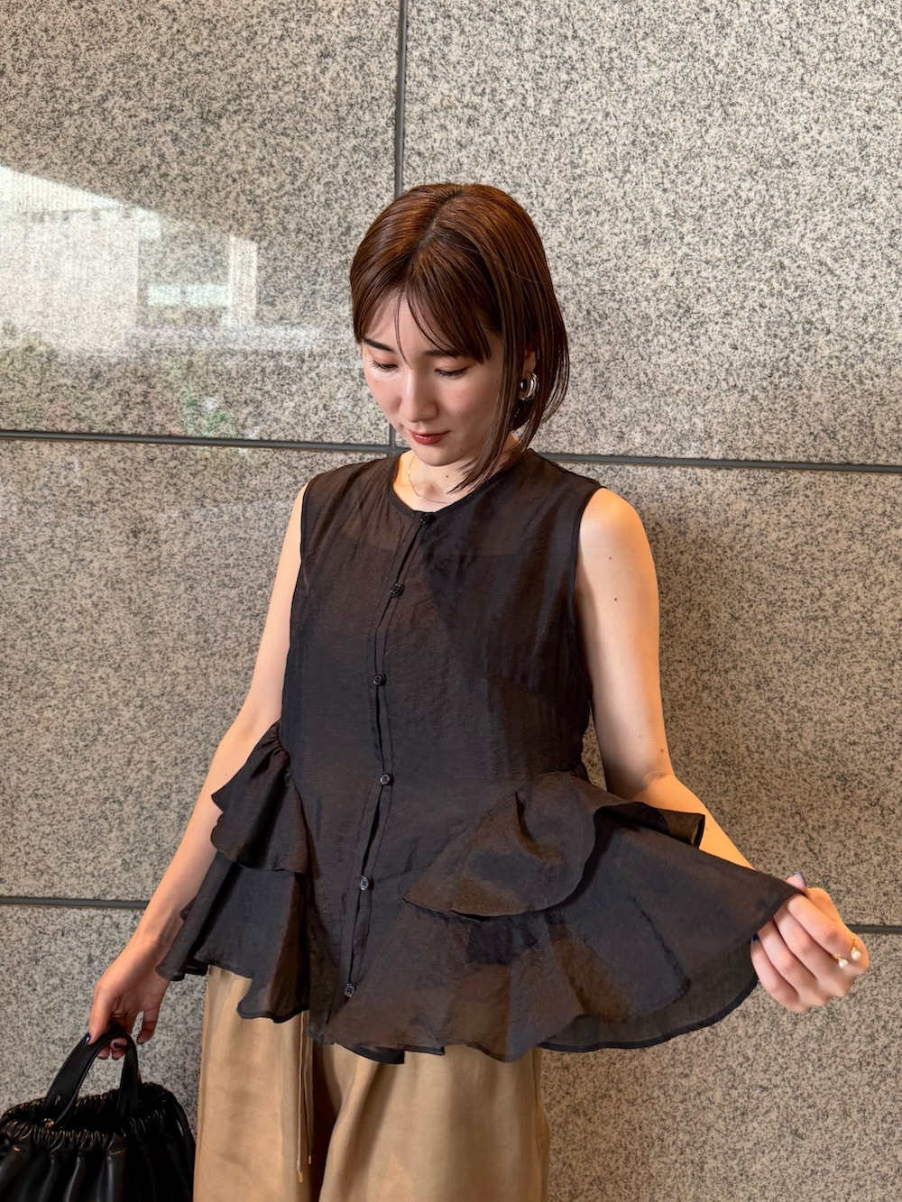 ブラック系のシャツ/ブラウス、ブラウン系のその他パンツ、ブラック系のバックパック/リュックを着用したレディースの春コーディネートの5枚目の写真