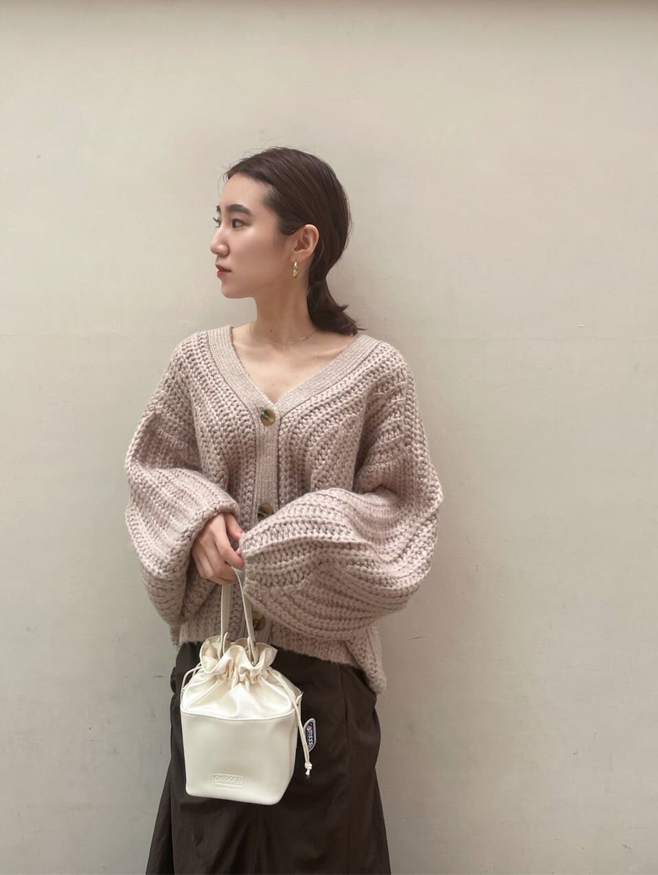 ブラック系のその他シューズ、ホワイト系のハンドバッグ、ブラウン系のスカートを着用したレディースの秋コーディネートの4枚目の写真