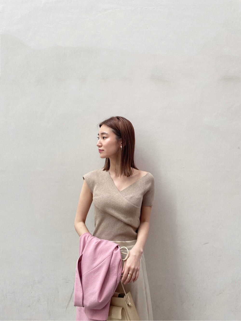 ホワイト系のスカート、その他のパンプス、ベージュ系のハンドバッグを着用したレディースの春コーディネートの5枚目の写真