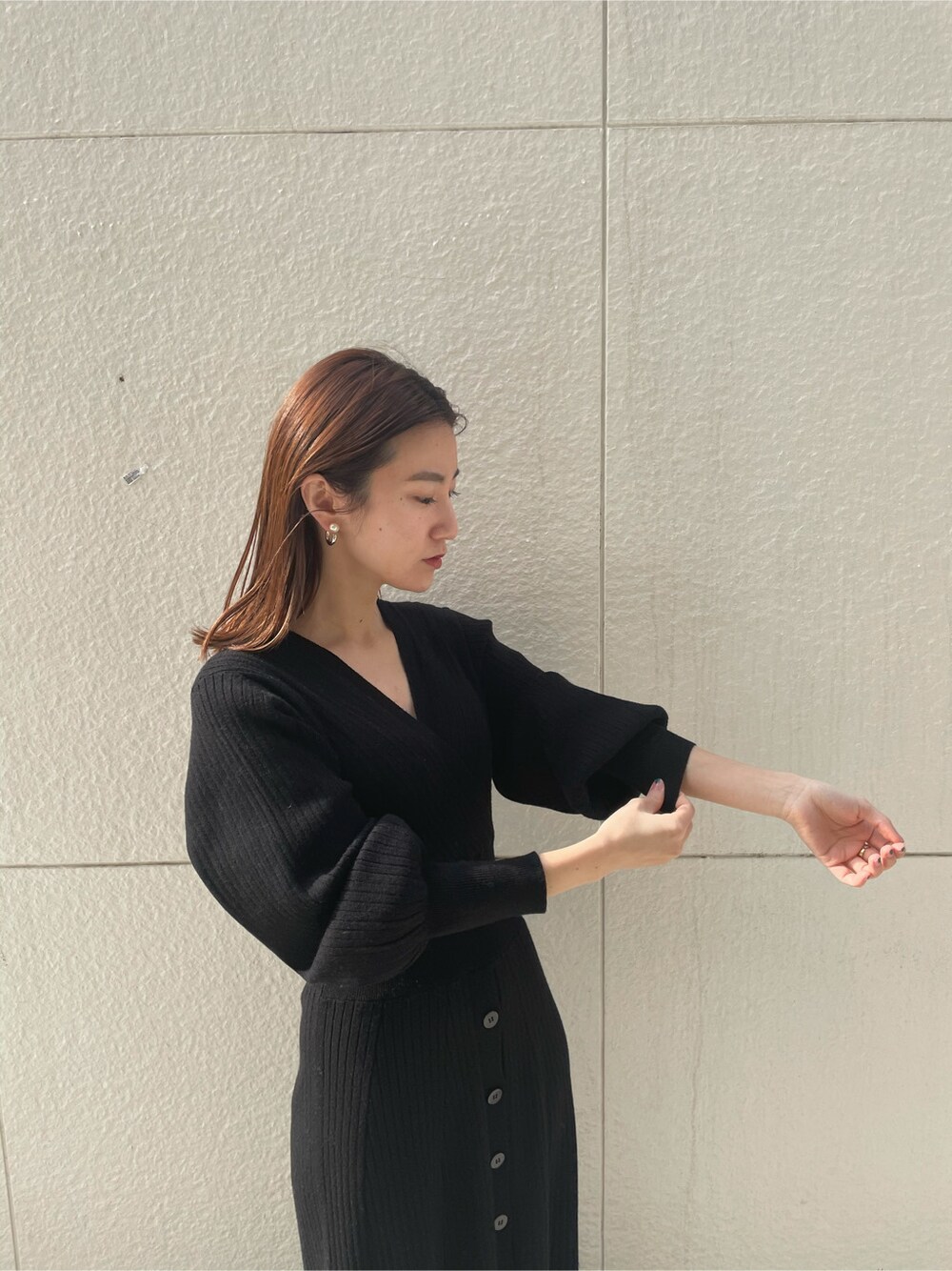 ブルー系のノーカラーコート、ブラック系のワンピースを着用したレディースの冬コーディネートの2枚目の写真